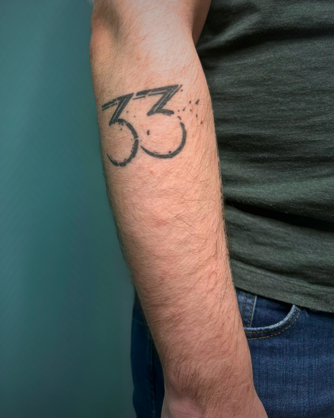 Un tattoo sur l'avant bras inspiré du logo de Clair Obscur : Expedition 33 - cicatrisé