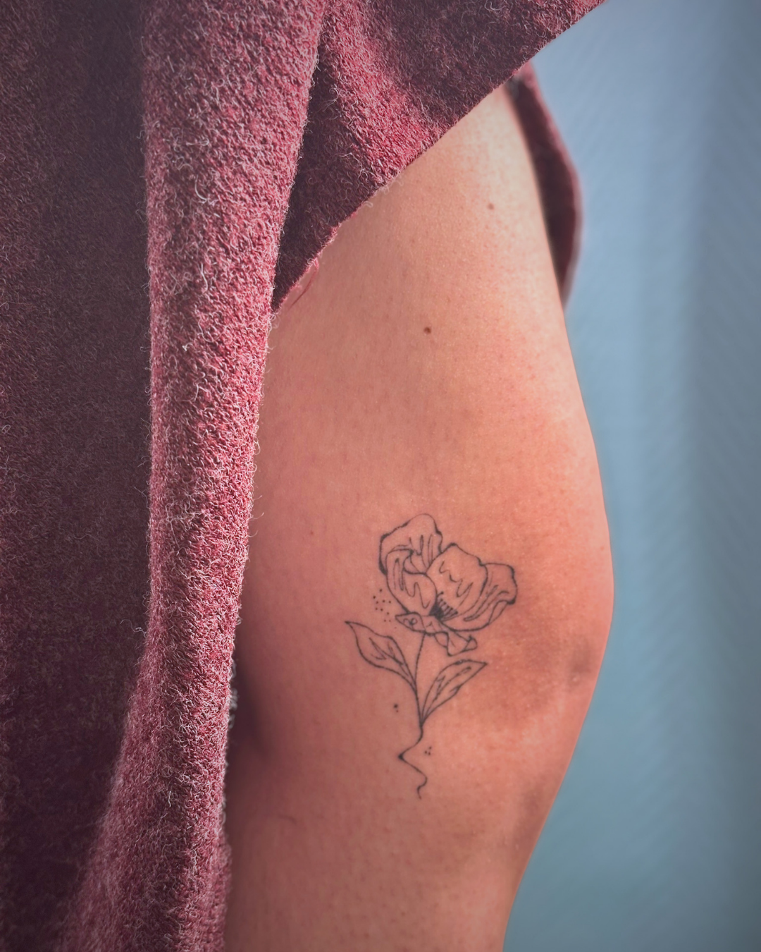 Tatouage floral graphique proche du genou