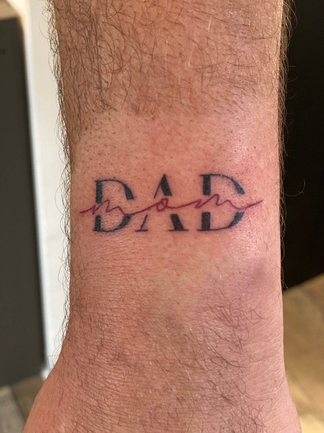 Tatouage d'un lettrage couleur sur le poignet