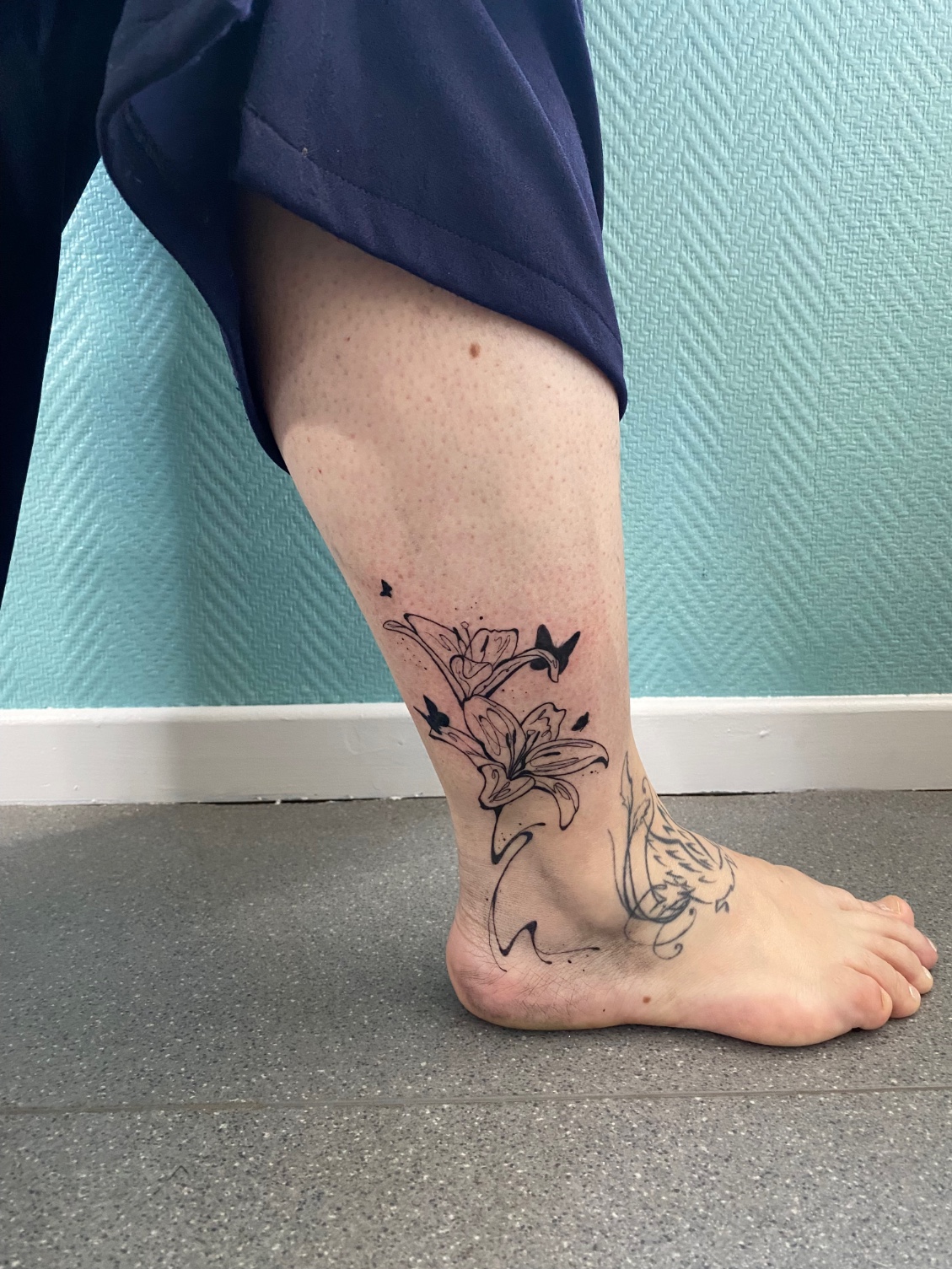 Tatouage floral graphique sur une cheville