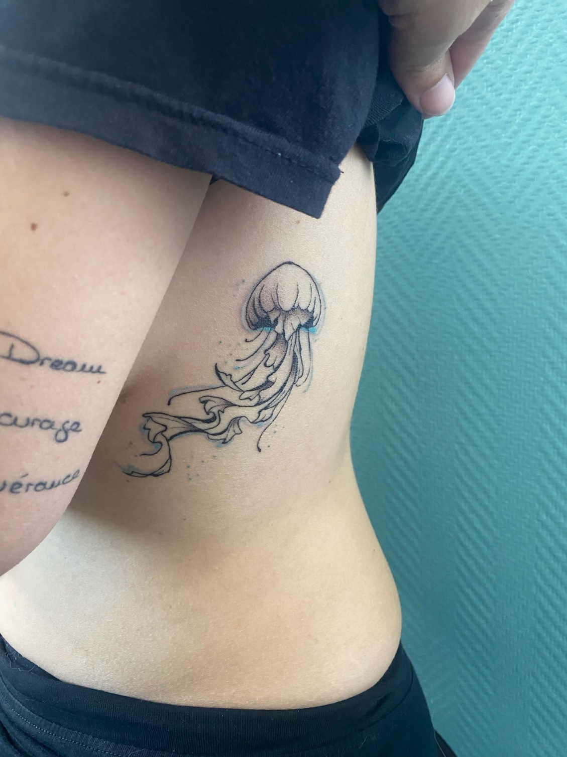 Tatouage d'une méduse avec un peu de couleur sur les côtes